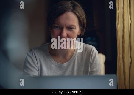 Glückliche, lächelnde Freiberuflerin, die am Laptop arbeitet, selektiver Fokus Stockfoto