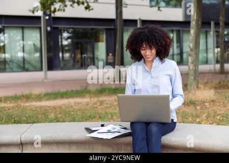 Unternehmerin, die aus der Ferne im Park arbeitet Stockfoto