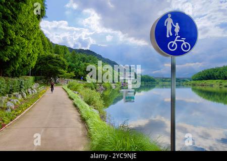 Ulsan, Südkorea - 9. Juli 2019: Ein Fahrrad- und Fußgängerweg entlang des Taehwa River, mit einem blauen Schild, das auf die gemeinsame Nutzung hinweist. Der Taehwa River Obs Stockfoto