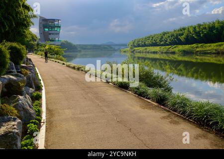 Ulsan, Südkorea - 9. Juli 2019: Ein malerischer Flussweg führt zum Taehwa River Observatory, umgeben von üppigem Grün und reflektierendem Kalk Stockfoto