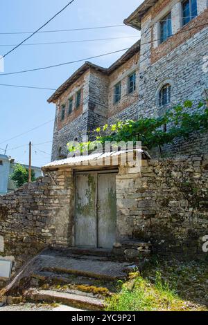 Ein altes Metallgartentor in einer traditionellen Steinmauer in der historischen Altstadt von Gjirokaster in Südalbanien. Gjirokaster ist berühmt für die osmanische Architektur Stockfoto