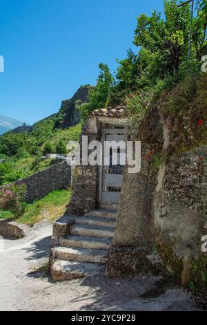 Ein altes Metallgartentor in einer traditionellen Steinmauer in der historischen Altstadt von Gjirokaster in Südalbanien. Gjirokaster ist berühmt für die osmanische Architektur Stockfoto