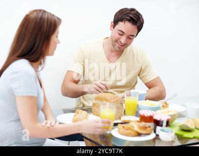 Schwangere Frau, Essen oder glückliches Paar zu Hause mit Frühstück für gesunde Ernährung oder Ernährung. Essen, Wellness oder Menschen, die eine Mahlzeit mit Schwangerschaft genießen Stockfoto