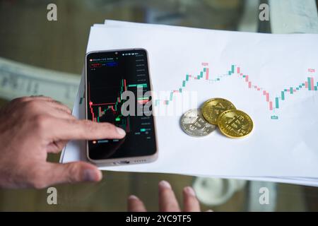 Indischer Händler, der Kryptowährung Bitcoin in Smartphones handelt, Blockchain-Technologie. Cyberbetrug und Anonym, Investitionen und Finanzen, riskantes Asset. Stockfoto