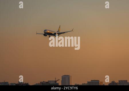 Ryanair-Flugzeug landet am Flughafen lissabon bei Sonnenuntergang mit orangefarbenem Himmel Stockfoto