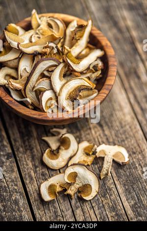 Getrocknete Stachelpilze. In Scheiben geschnittener Boletus in einer Schüssel auf einem Holztisch. Stockfoto