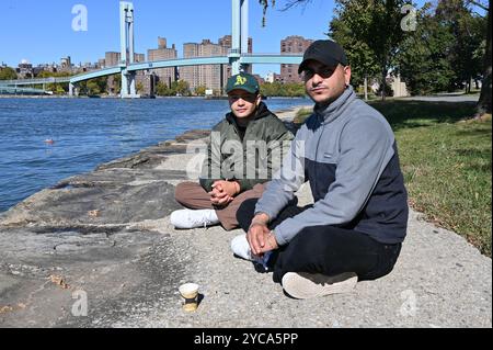 New York, Usa. Oktober 2024. Zehntausende Migranten warten in New York auf ein besseres Leben in der Unsicherheit vor den Wahlen. Auf dem Foto vom 18. Oktober 2024 sind Santiago und Andres aus Kolumbien am Ufer von Randall's Island zu sehen. Quelle: Alan Lexa/CTK Photo/Alamy Live News Stockfoto