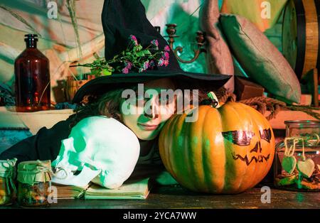 Halloween-Kind. Heim Halloween Atmosphäre. Mädchen mit Kürbis verkleidet wie Vampir für Halloween-Party. Fröhliche Kinder an Halloween. Kinderaugen mit Stockfoto