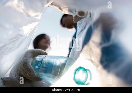 Freiwilliger aus der Gemeinde sammelt Plastikflaschen für das Recycling im Rahmen von Umweltschutzmaßnahmen Stockfoto