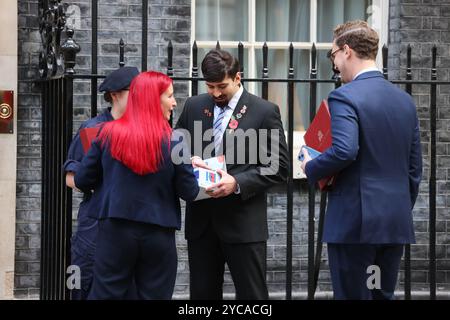 London, UK, 22. Oktober 2024. Vor dem offiziellen Start des Poppy Appells der Britischen Legion am Donnerstag, den 24. Oktober, besuchten Sammler und Veteranen die Downing Street Nr. 10, damit Premierminister Keir Starmer, gefolgt von Mitgliedern des Kabinetts, spenden und einen Mohn kaufen konnte. Kredit : Monica Wells/Alamy Live News Stockfoto