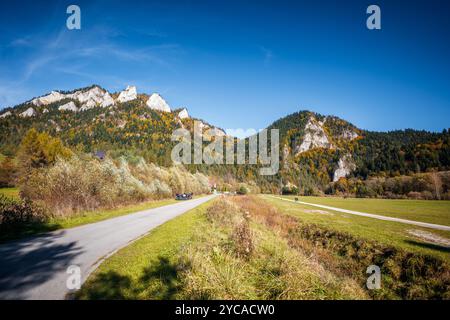 Wunderschöne Berge mit felsigen Gipfeln im Herbst an einem sonnigen Tag. Pieniny Mountains. Asphaltstraße am Fuße der Berge Blick auf Trzy Korony (drei Stockfoto