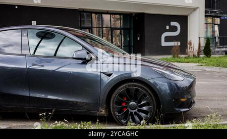 Minsk, Weißrussland, 22. Oktober 2024 - moderner Tesla-Wagen parkt in der Nähe des Gebäudes Stockfoto