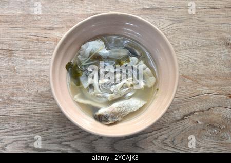 Gekochter Bassfischkopf und Ingwer in Pflaumensuppe auf einer Schüssel schneiden Stockfoto