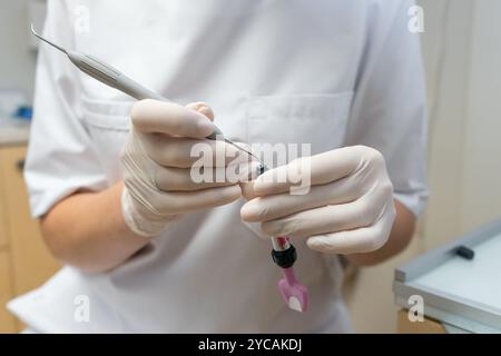 Zahnarzt in sterilen Handschuhen zur Vorbereitung der Zahnfüllung zur Behandlung von Patientenzähnen Stockfoto