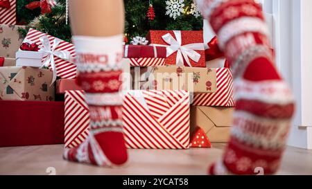 Ordentlich verpackte Geschenkboxen unter dem modernen Weihnachtsbaum in einem Haus, ergänzt durch Weihnachtsschmuck, eine festliche Neujahrsdekoration. Stockfoto