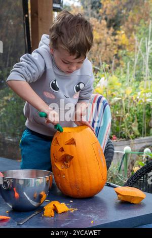 Denver, Colorado - Ein sechsjähriger Junge schnitzt einen Halloween-Kürbis. Stockfoto