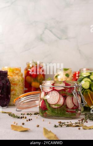 Frische Radieschen mit Gärung in einem Glas mit Gewürzen, die ein gesundes probiotisches Essen schaffen, frisches fermentierendes Gemüse wie Kohl, Tomaten, Cucum Stockfoto