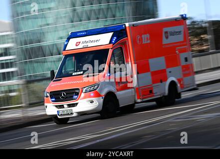 PRODUKTION - 22. Oktober 2024, Hessen, Frankfurt/Main: Ein Krankenwagen des Malteser Hilfsdienstes ist mit blauem Licht auf dem Weg zum Universitätsspital (mit langsamerer Verschlusszeit aufgenommen). Foto: Arne Dedert/dpa Stockfoto