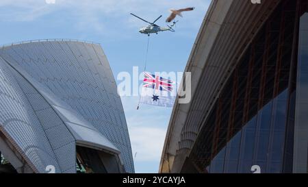 Sydney, Australien. Oktober 2024. Ein Militärhubschrauber mit der Australian Navy Flag ist zwischen den Segeln des Sydney Opera House zu sehen, während Queen Camilla und König Charles III. Am 22. Oktober 2024 in Sydney, Australien, das Opernhaus von Sydney besuchen. Credit: IOIO IMAGES/Alamy Live News Stockfoto