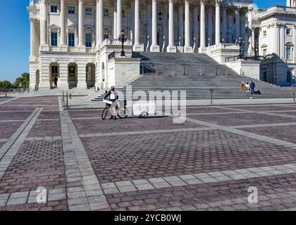 Capitol Police folgt einem eifrigen Anti-Trump-Radfahrer, der am 20. Oktober 2024 einen Trailer „Trump Brand 666 (Hellbound, USA)“ auf dem Gelände des US-Kapitols zieht. Stockfoto