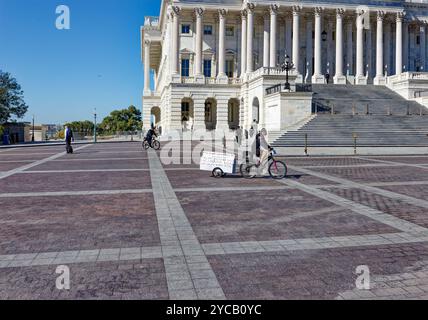 Capitol Police folgt einem eifrigen Anti-Trump-Radfahrer, der am 20. Oktober 2024 einen Trailer „Trump Brand 666 (Hellbound, USA)“ auf dem Gelände des US-Kapitols zieht. Stockfoto