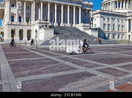 Capitol Police folgt einem eifrigen Anti-Trump-Radfahrer, der am 20. Oktober 2024 einen Trailer „Trump Brand 666 (Hellbound, USA)“ auf dem Gelände des US-Kapitols zieht. Stockfoto