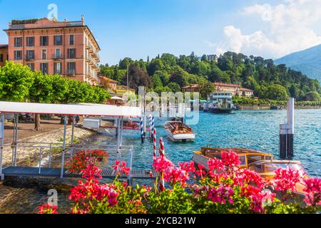 Touristenpiers und Boote in der Stadt Bellagio am Comer See, Blumen im Vordergrund. Lombardei, Italien, Europa. Stockfoto