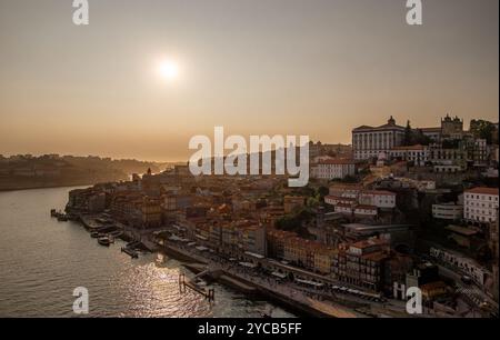 Fesselndes Luftbild von Porto bei Sonnenuntergang, das die historische Architektur der Stadt mit dem ruhigen Fluss Douro in goldenes Licht getaucht zeigt Stockfoto