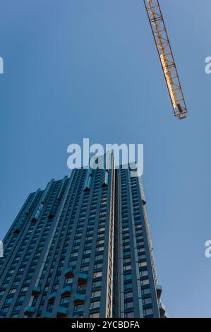 Ein Kran und ein modernes Gebäude im Bau, vertikaler Tiefwinkelschuss Stockfoto