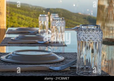 Restauranttische für das Abendessen mit Gläsern und Tellern für Gäste oder Gäste Stockfoto