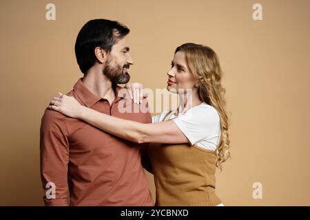 Ein Mann und eine Frau teilen einen zärtlichen Moment, lächeln und blicken einander an, strahlen Zuneigung aus. Stockfoto