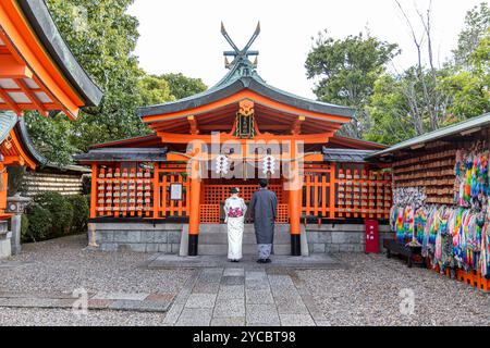 Ein Paar mit japanischen Kimonos steht im fushimi inari-Schrein Stockfoto