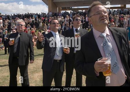 Eine Gruppe von Männern trinkt Bier und beobachtet die Pferde, die auf den öffentlichen Ständen im Royal Ascot laufen. Tragen Anzug und Krawatte, elegant gekleidet für einen Tag frei von der Arbeit. Berkshire England 2006 2000er Jahre Großbritannien HOMER SYKES Stockfoto