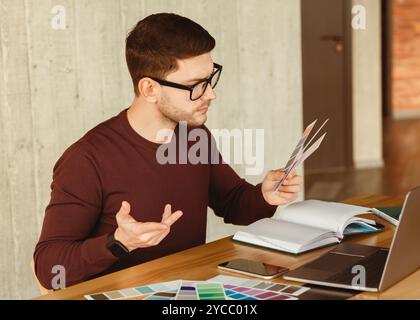 Freiberuflicher Designer, Der Mit Farbmustern Arbeitet, Die Im Büro Sitzen Stockfoto