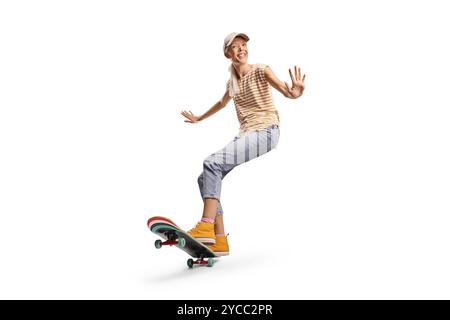 Junge Frau, die auf einem Longboard reitet und auf weißem Hintergrund lächelt Stockfoto