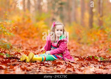 Glückliche Kinder spielen im schönen Herbst Park an warmen sonnigen Herbsttag. Kinder spielen mit goldenen Ahornblättern. Stockfoto