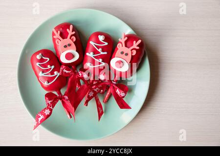 Flache Schicht von Kuchen Pops Eis auf einem Stock in rosa Glasur mit Erdbeeren und Heidelbeeren auf hellem Hintergrund. Stockfoto