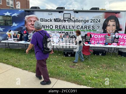 Racine, Wisconsin, USA. Oktober 2024. SACARIA FOLWER führt den Bus „Black Males Challenge – Who really CARES“ aus, der am Dienstag Morgen des 22. Oktober 2024 gegenüber dem Rathaus in Racine, Wisconsin, geparkt wird. Die Initiative hat ihren Sitz in Atlanta. Hemden und Hüte für die Harris- und Trump-Kampagnen stehen zum Verkauf. FOWLER sagte, der Bus fährt zwischen Michigan und Wisconsin. Der demokratische Vizepräsident Tim Walz soll am Abend eine Kundgebung in der Innenstadt von Racine veranstalten. (Kreditbild: © Mark Hertzberg/ZUMA Press Wire) REDAKTIONELLE VERWENDUNG AUF Stockfoto