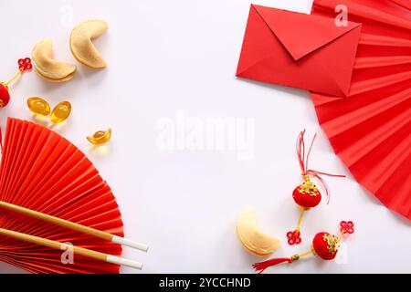 Roter Umschlag mit chinesischen Symbolen, Essstäbchen und Glückskeksen auf weißem Hintergrund. Neujahrsfeier Stockfoto