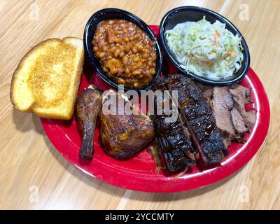 Ein amerikanisches Abendessen mit gegrilltem Huhn, Rippchen und Rinderbrust mit gebackenen Bohnen und Krautsalat Stockfoto