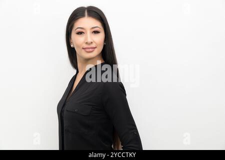 Junge und süße schöne schwarze lange Haare asiatische Frau posiert selbstbewusst auf weißem Hintergrund. Stockfoto