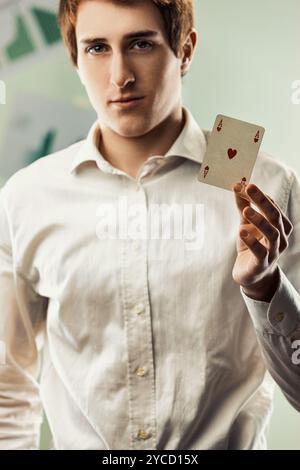 Der Geschäftsmann zeigt das Herz-Ass, das in seinem Büro steht. Dieses Bild kann verwendet werden, um Konzepte wie Business, Strategie und darzustellen Stockfoto