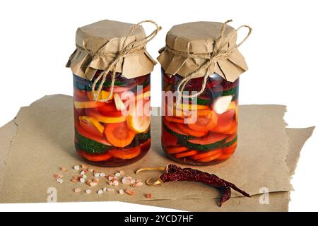 Zwei Gläser mit gesalzenem fermentiertem Gemüse auf weißem Hintergrund. Stockfoto