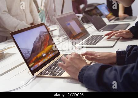 Kunden wählen in einem Elektronikgeschäft einen Laptop aus. Laptops zum Verkauf an der Theke in einem Computergeschäft Stockfoto