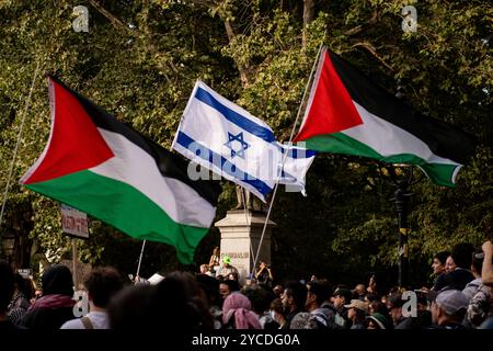 Manhattan, Usa. Oktober 2024. Pro-israelische und pro-palästinensische Demonstranten halten ihre Fahnen über einer Menge von Demonstranten während einer Massendemonstration im Washington Square Park. Hunderte pro-palästinensischer Demonstranten versammelten sich, um durch die Straßen von Manhattan zu marschieren, um gegen die militärischen Aktionen zu protestieren, die der Staat Israel derzeit in der Region durchführt, von denen Palästinenser sowohl im Gazastreifen als auch im Westjordanland sowie im Libanon betroffen sind. Quelle: SOPA Images Limited/Alamy Live News Stockfoto