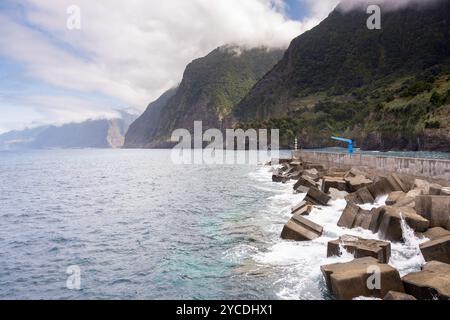 Die Küste von Seixal mit großen Klippen und der Hafen mit dem Wasserfall Véu da Noiva im Hintergrund. Insel Madeira, Portugal Stockfoto