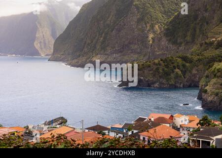 Seixal Dorf und Küste mit großen Klippen und dem Véu da Noiva Wasserfall im Hintergrund. Insel Madeira, Portugal Stockfoto