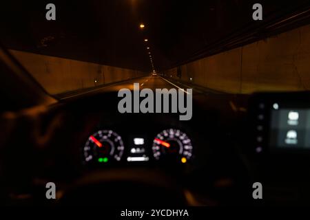 Blick aus dem Inneren eines Autos, das nachts in einem großen Tunnel in gerader Linie fährt. Fahrer-POV, der in einem Tunnel fährt. Stockfoto