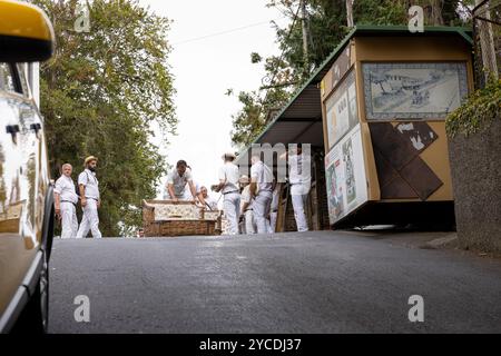 Monte, Madeira - 01.10.2024: Traditionelle Rodelfahrer entspannen sich bis zur nächsten Reise. Insel Madeira, Portugal Stockfoto