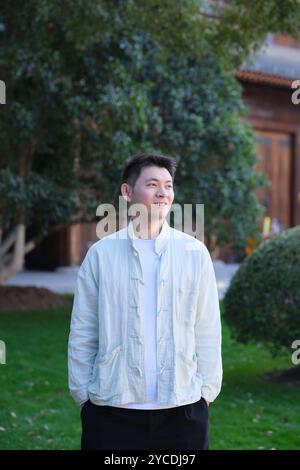 Lächelnder chinesischer junger Mann, der wegschaut Stockfoto